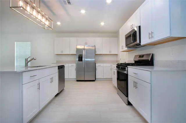a kitchen with stainless steel appliances a refrigerator sink and cabinets