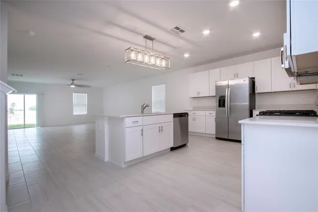 a large kitchen with cabinets wooden floor and stainless steel appliances