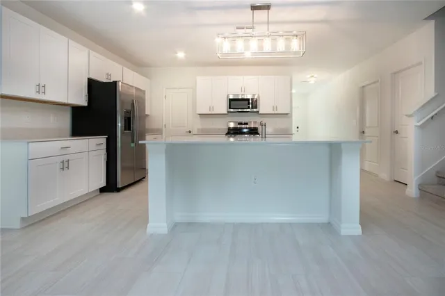 a kitchen with stainless steel appliances granite countertop a stove and a microwave