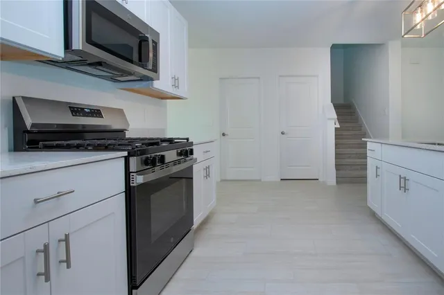 a kitchen with white cabinets and stainless steel appliances