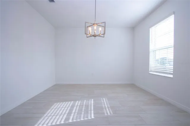 a view of a livingroom with a ceiling fan & kitchen space