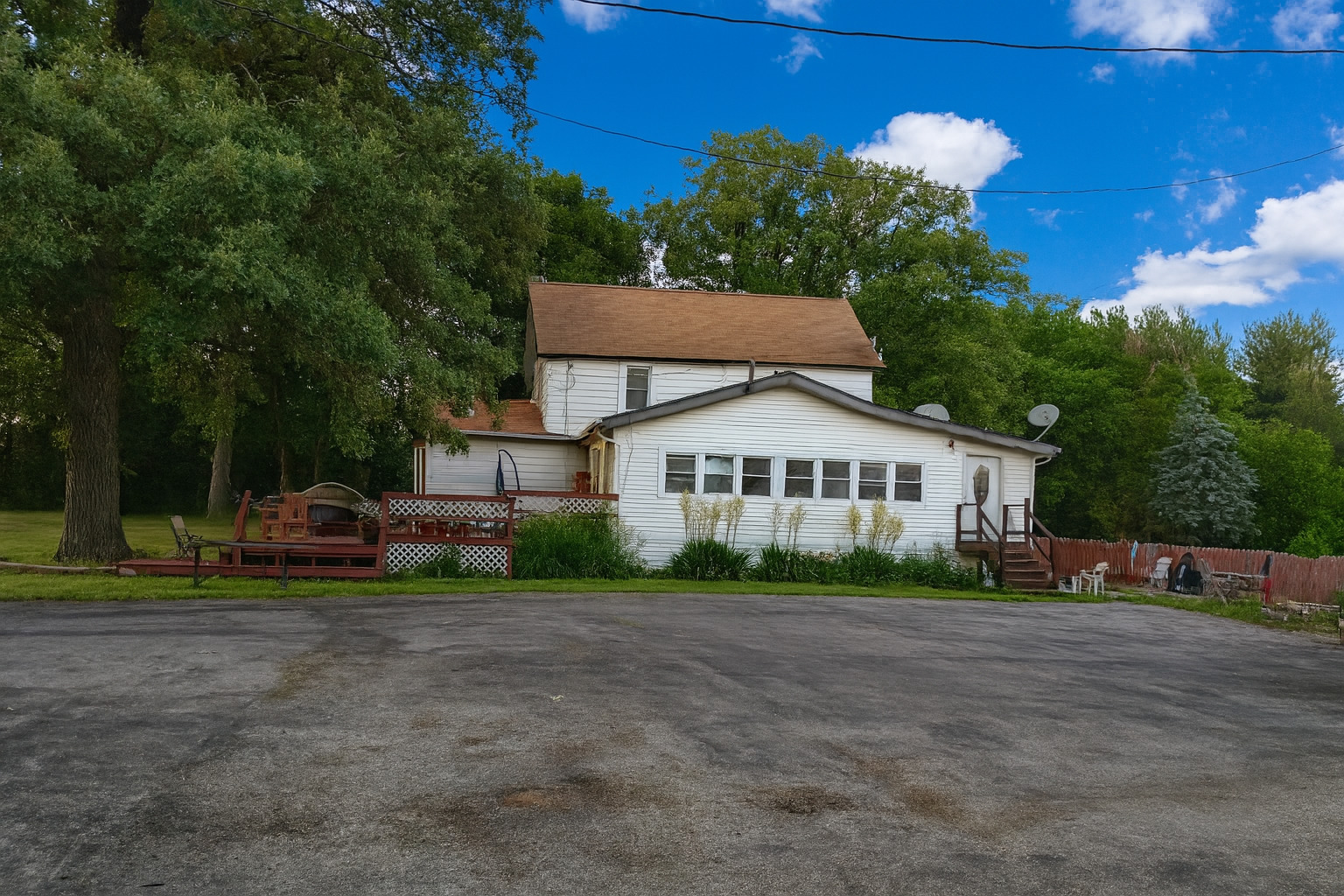 a view of a house with a big yard and large trees