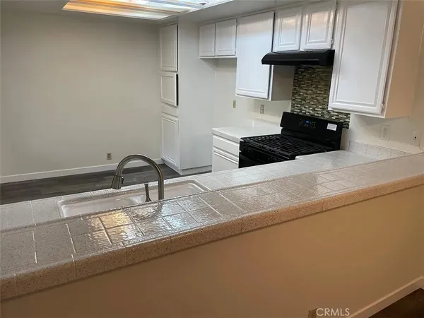 a kitchen with granite countertop stainless steel appliances a sink a stove and a refrigerator