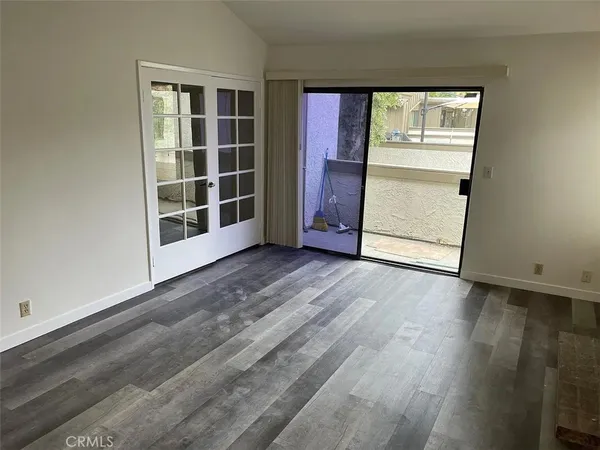 an empty room with wooden floor and cabinet