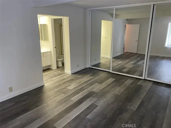 an empty room with wooden floor and a mirror