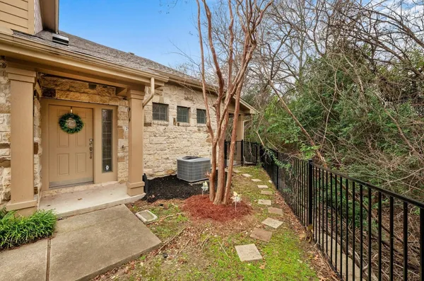 a view of a house with backyard and wooden fence