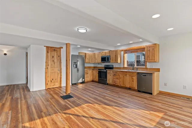 a large kitchen with stainless steel appliances granite countertop a stove and a refrigerator