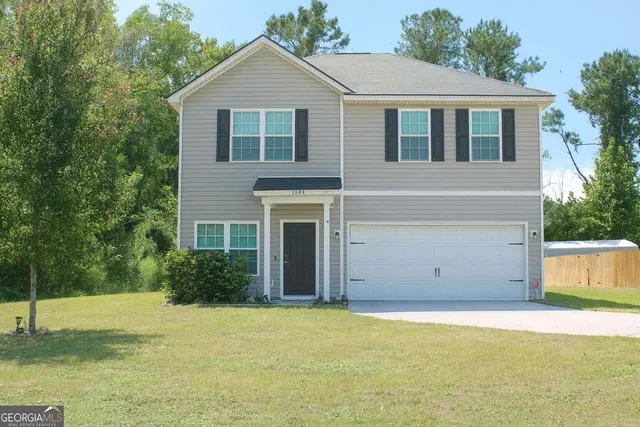 a view of a house with backyard and trees