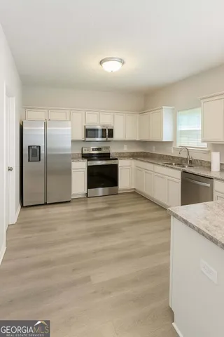 a kitchen with a refrigerator sink and stove top oven