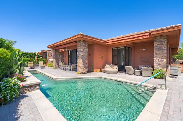 a view of a house with backyard sitting area and garden