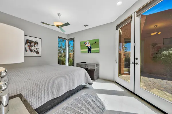 a bedroom with a large bed and a chandelier