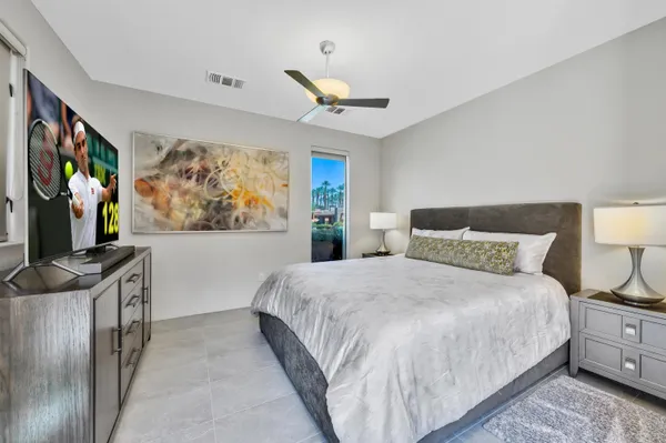 a bedroom with a large bed and a flat screen tv