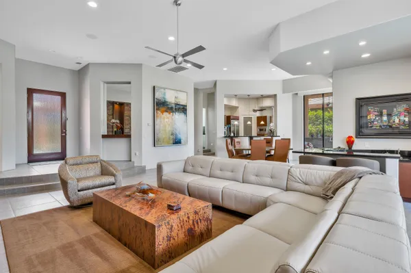 a living room with furniture kitchen and a chandelier