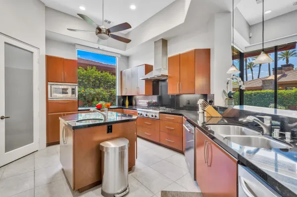 a kitchen with stainless steel appliances granite countertop a sink a stove and a refrigerator