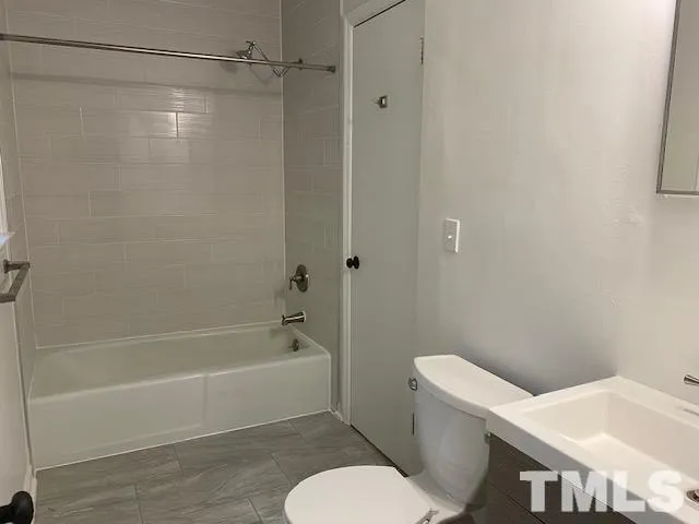 a white toilet and tub sitting next to a bathroom sink