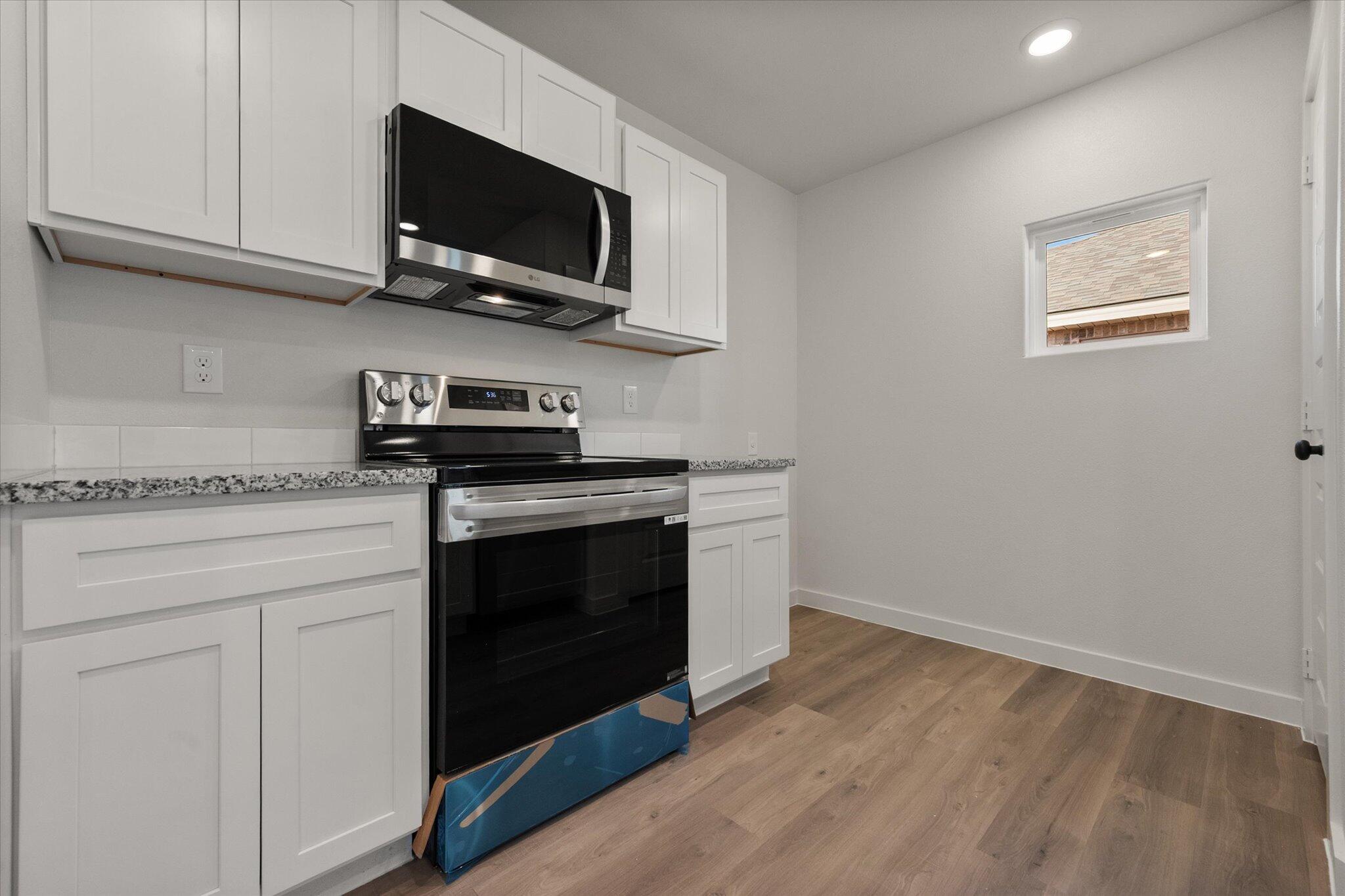 6308 Volney Avenue Lubbock, TX 79407 - Photo 9 of 19 a kitchen with stainless steel appliances granite countertop a stove microwave and oven