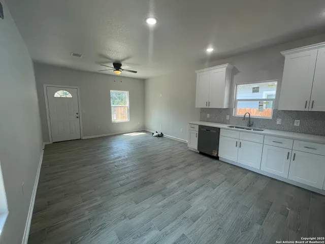 a view of a kitchen with sink cabinets and wooden floor