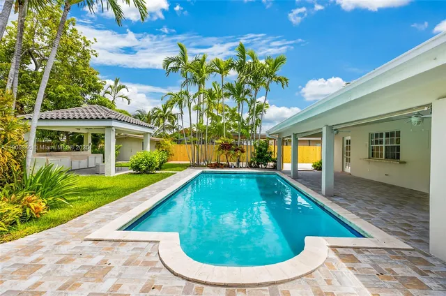 a view of swimming pool on a sunny day with lawn chairs