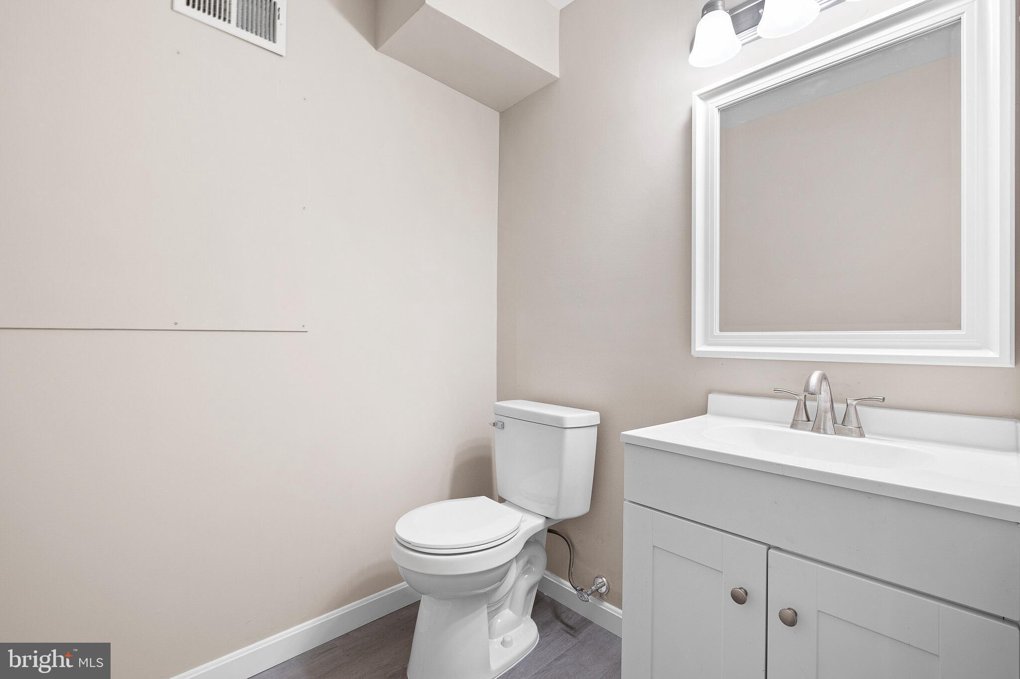 1301 Shallcross Avenue Wilmington, DE 19806 - Photo 24 of 33 a bathroom with a toilet a sink and mirror