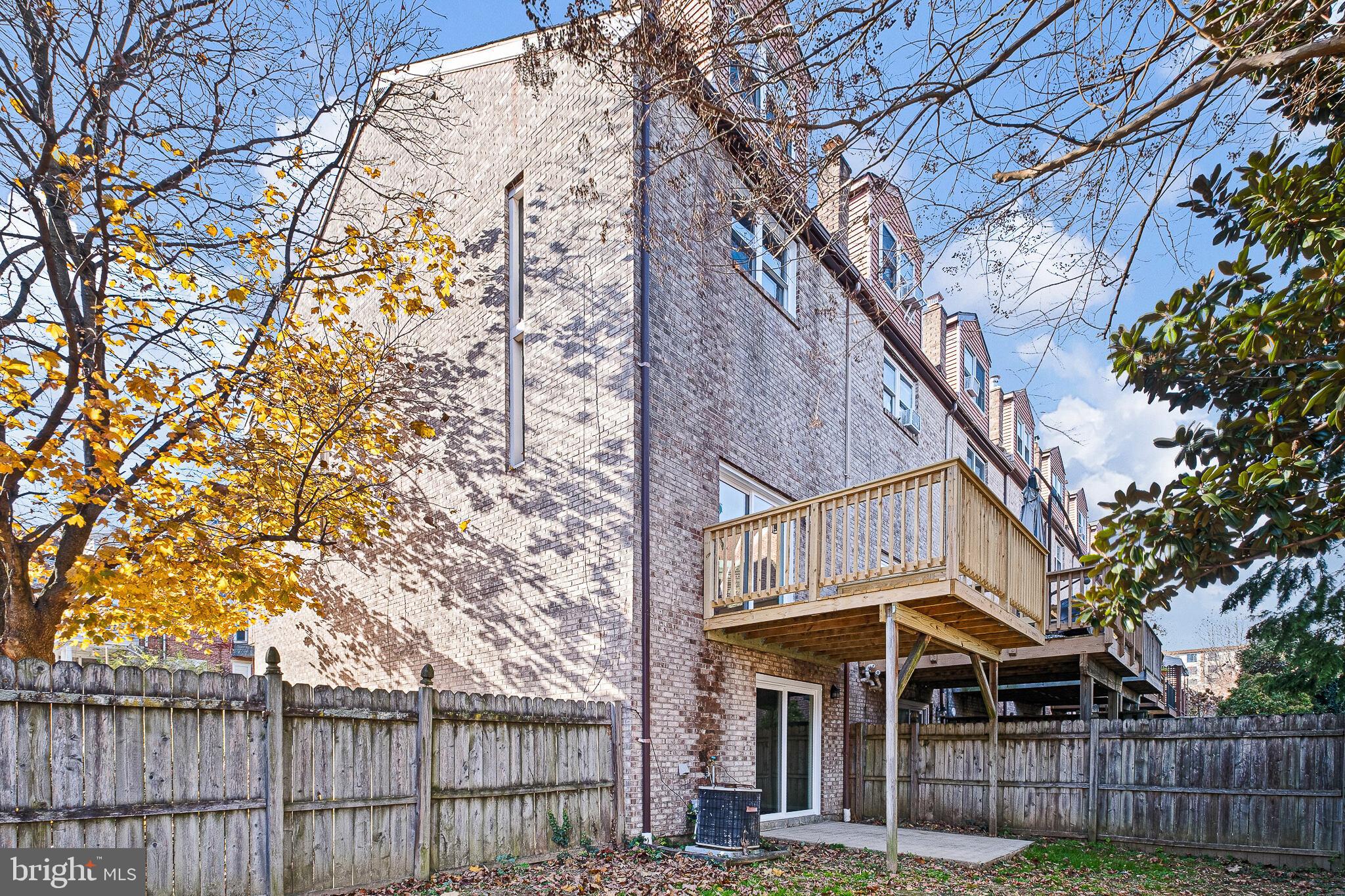 1301 Shallcross Avenue Wilmington, DE 19806 - Photo 28 of 33 a view of a brick house with large trees and wooden fence