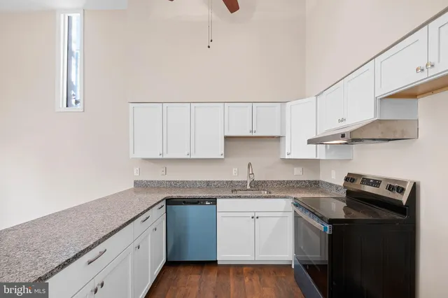 a kitchen with stainless steel appliances granite countertop a sink stove and cabinets