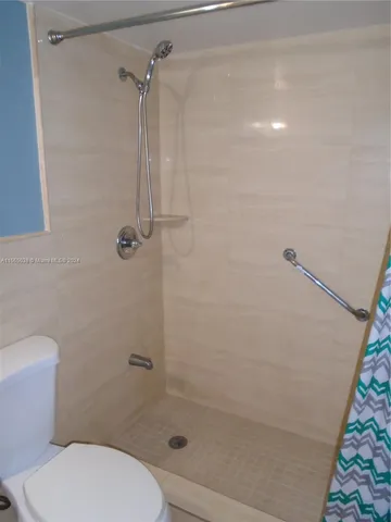 a bathroom with a toilet and a shower