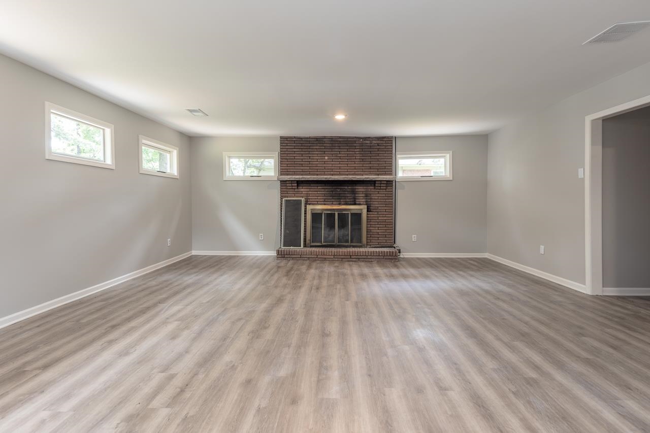 1461 Phillips Road Memphis, TN 38134 - Photo 17 of 19 a view of an empty room with wooden floor fireplace and a window