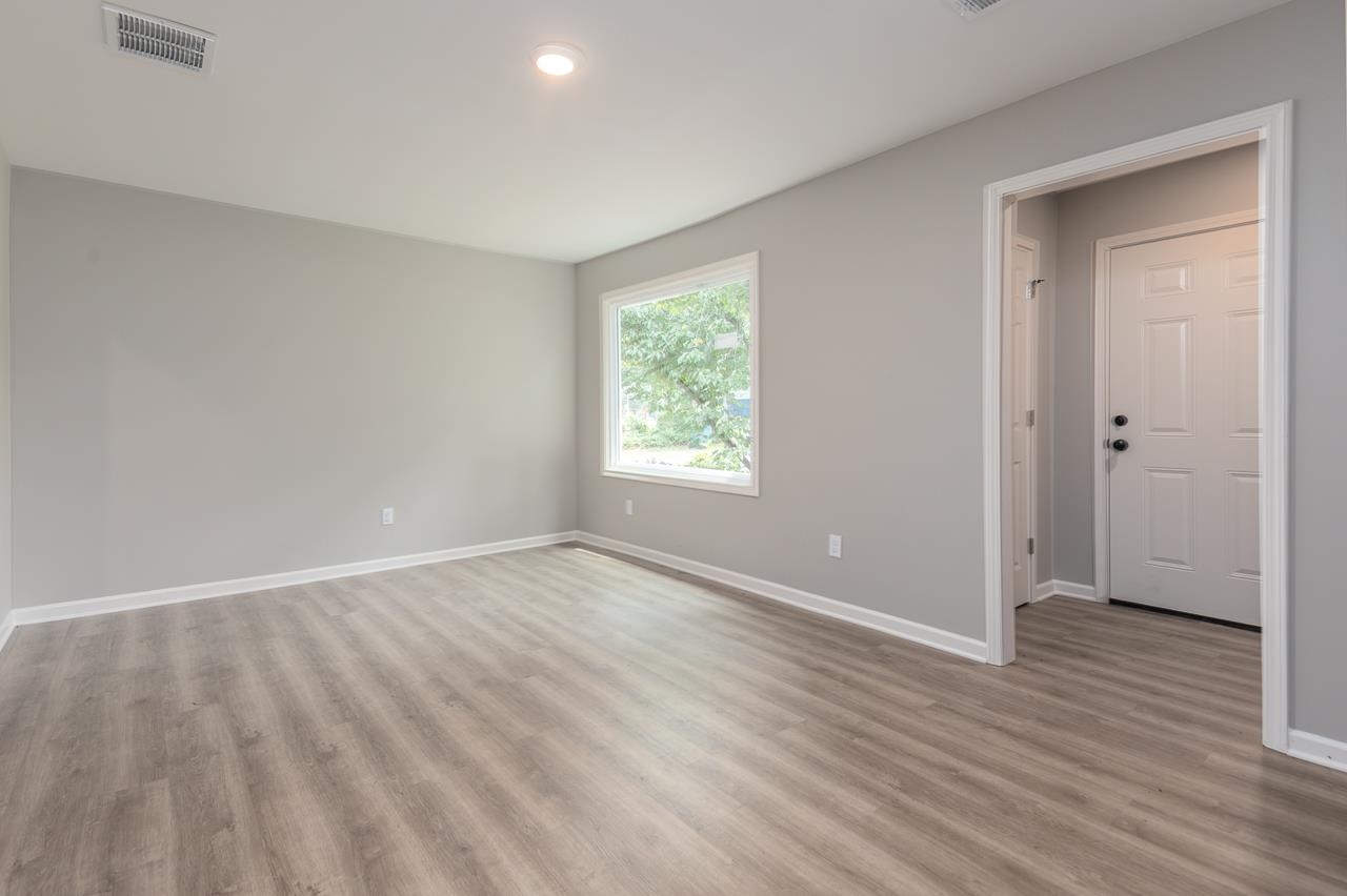 1461 Phillips Road Memphis, TN 38134 - Photo 3 of 19 a view of an empty room with wooden floor and a window