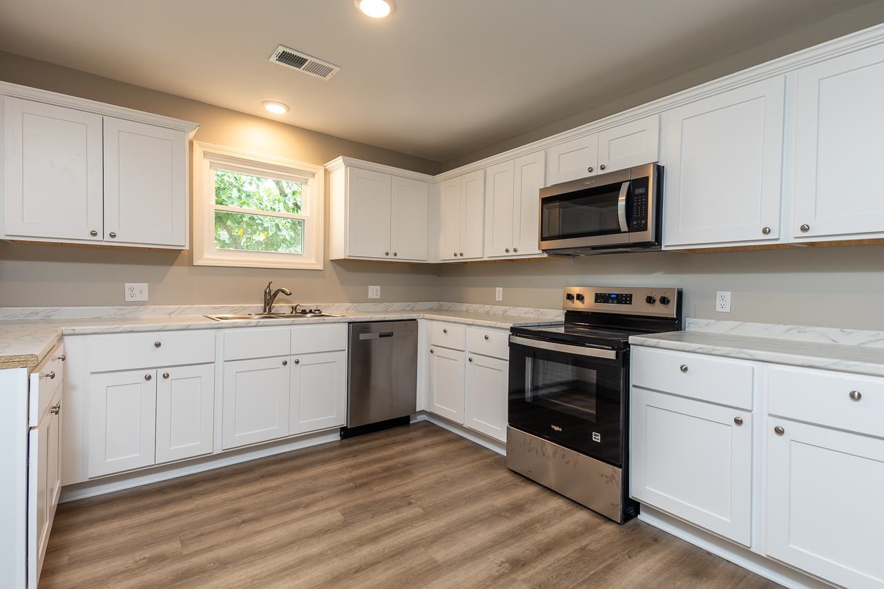 1461 Phillips Road Memphis, TN 38134 - Photo 6 of 19 a kitchen with stainless steel appliances granite countertop a sink a stove a microwave and cabinets