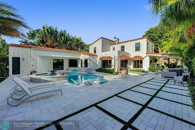 a view of a dining room with furniture a chandelier and large windows