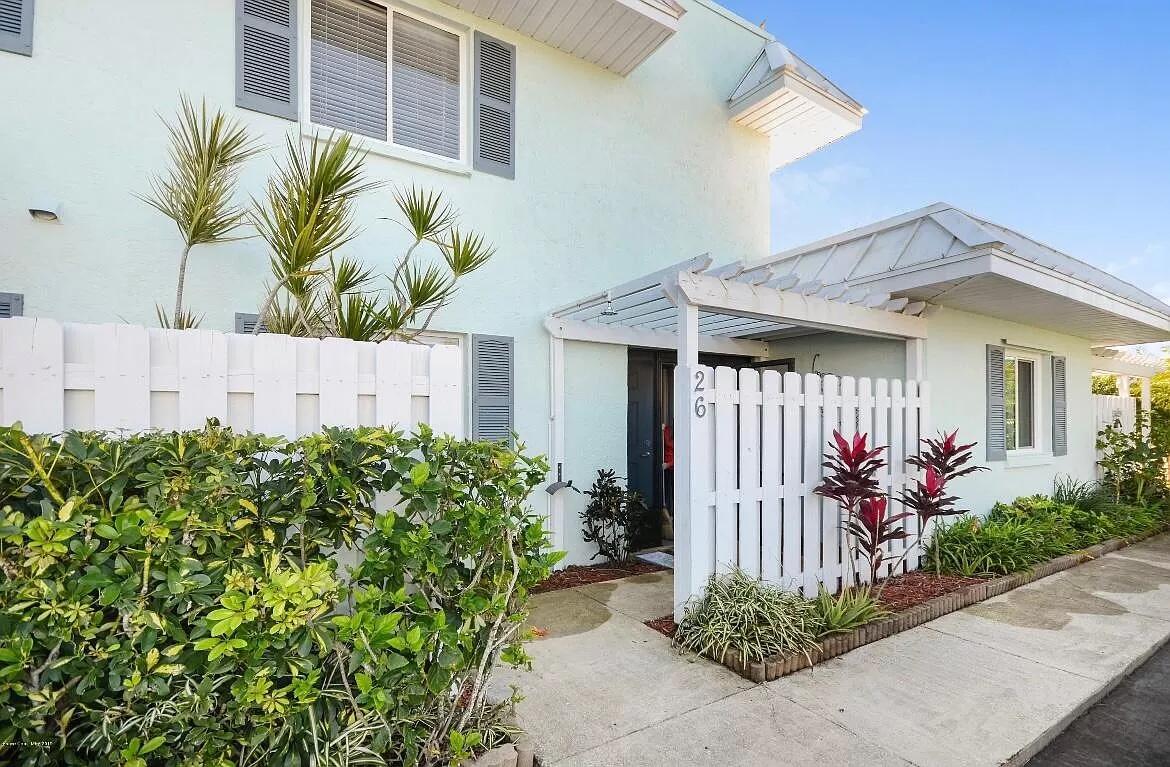 2 Country Club Road, Unit 26 Cocoa Beach, FL 32931 - Photo 3 of 10 a front view of a house with a lot of flower plants