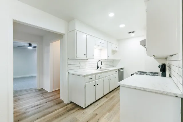 a view of a kitchen with sink and wooden floor