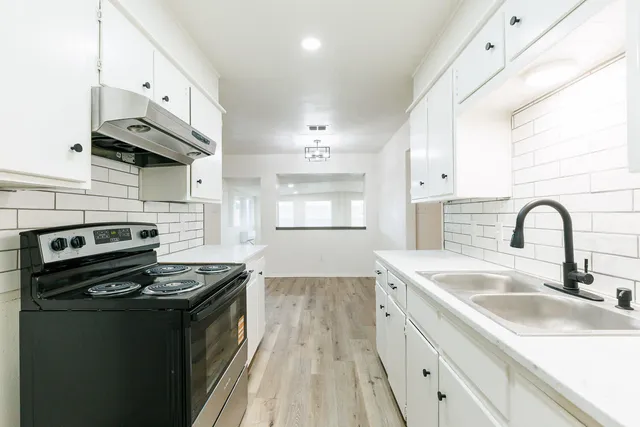 a kitchen with stainless steel appliances a white stove top oven and sink