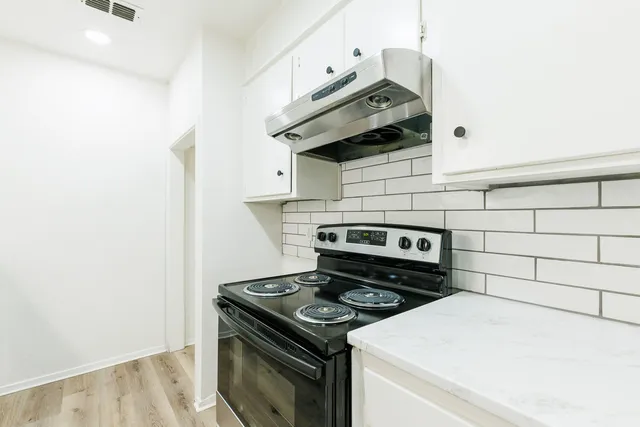 a stove top oven sitting inside of a kitchen
