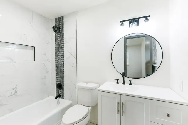 a bathroom with a toilet sink and mirror