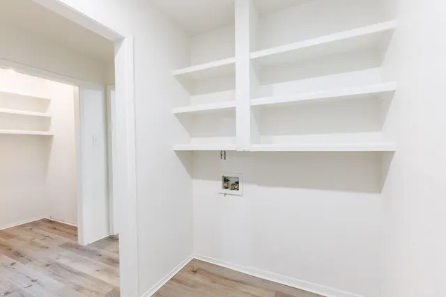 a view of a closet with wooden floor