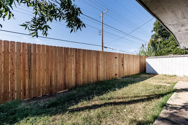 a view of a backyard with wooden fence