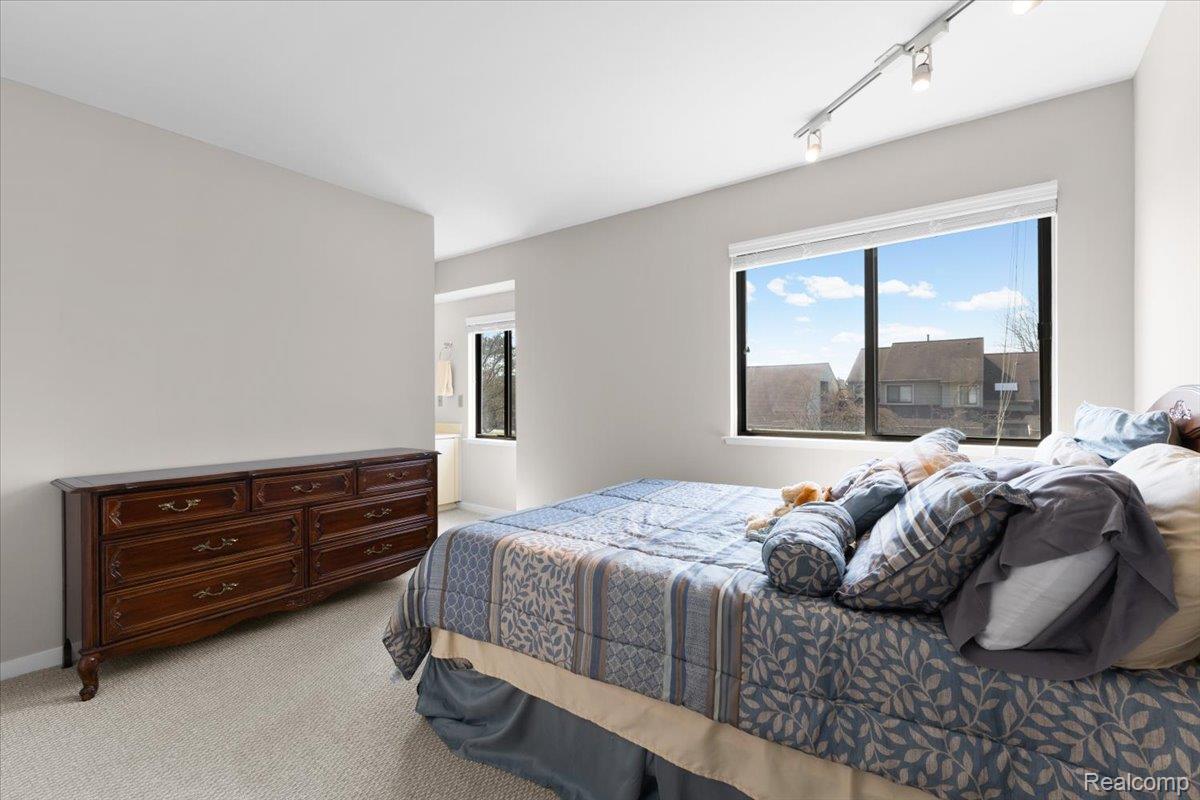 630 Ashley Circle East Rochester, MI 48307 - Photo 16 of 22 Bedroom with light colored carpet and rail lighting