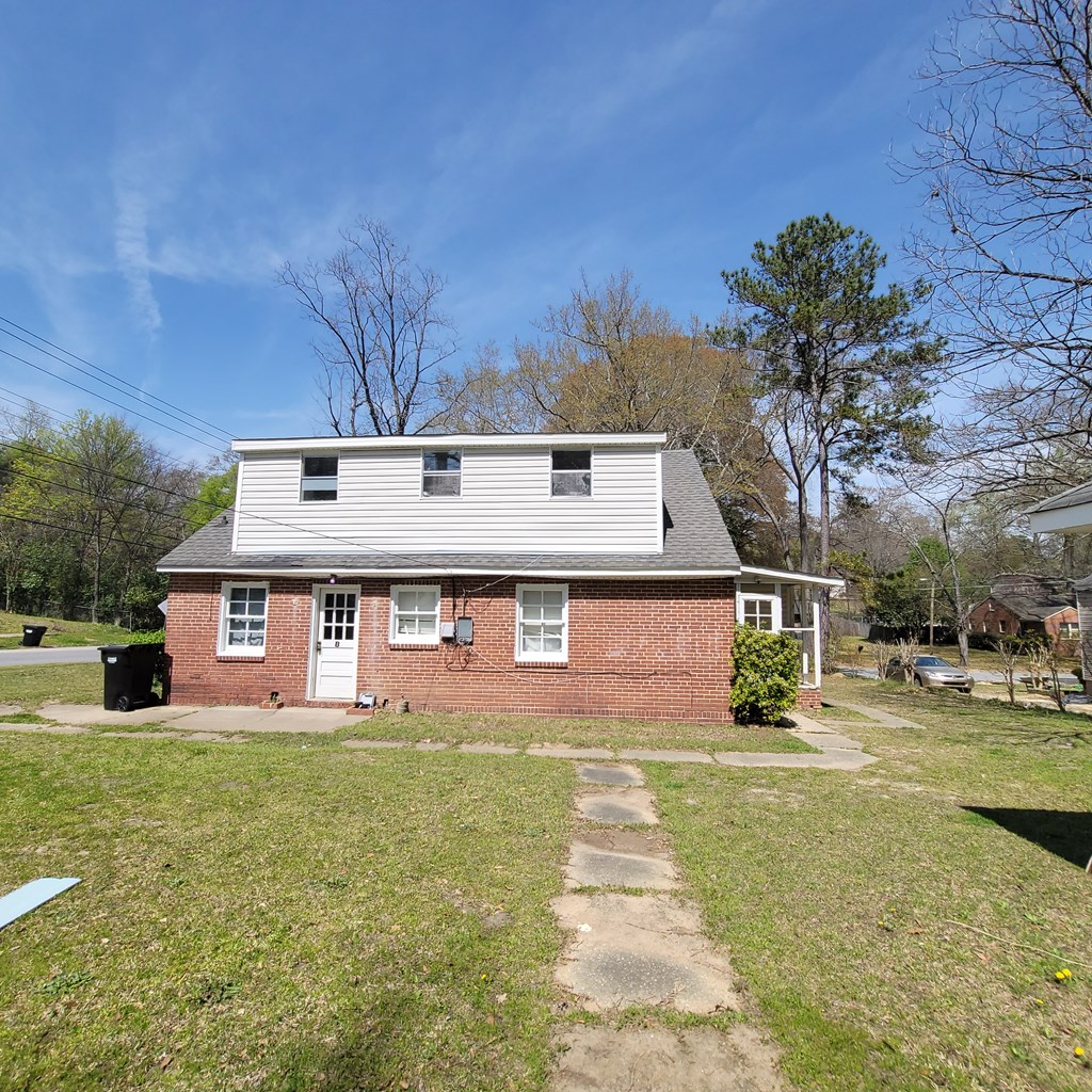 1702 40th Street, Unit C Columbus, GA 31904 - Photo 2 of 10 a front view of a house with a yard and garage