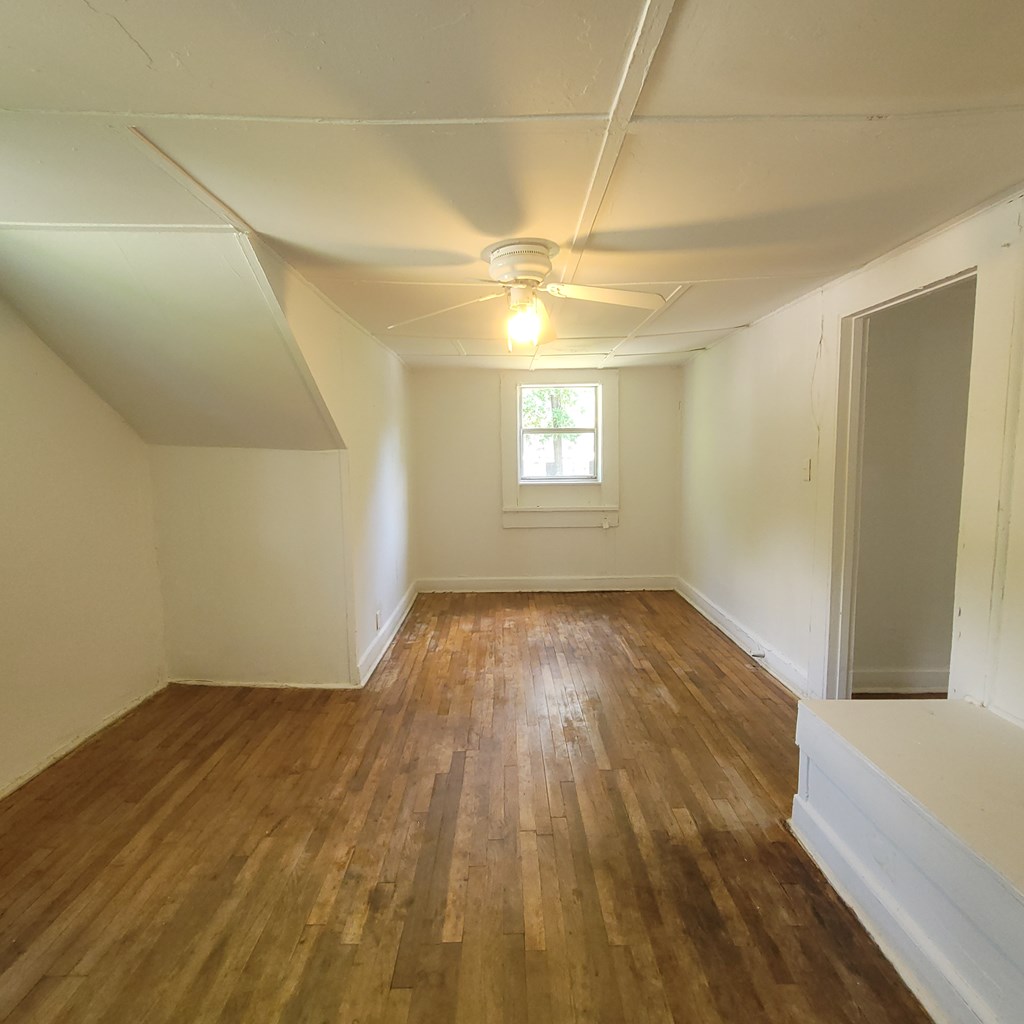 1702 40th Street, Unit C Columbus, GA 31904 - Photo 9 of 10 an empty room with wooden floor and windows
