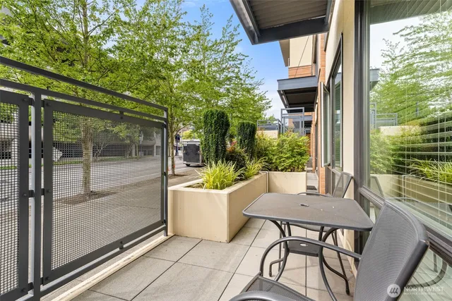 a view of a patio with table and chairs and floor to ceiling window