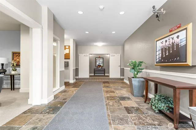 a view of a hallway with wooden floor and a potted plant