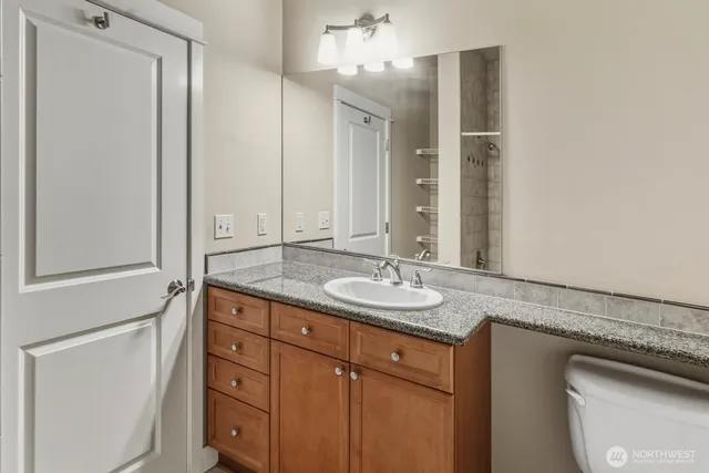 a bathroom with a granite countertop sink and a mirror