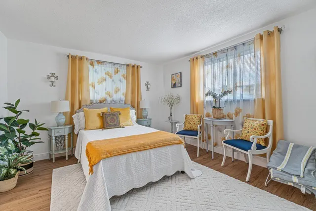 a bedroom with a bed and large windows