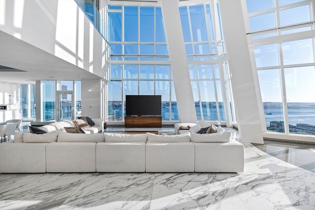 a living room with furniture a flat screen tv and a large window