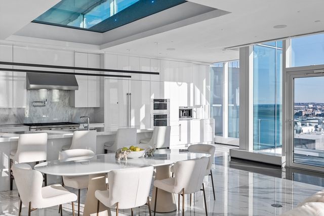 a kitchen with a table chairs and white cabinets