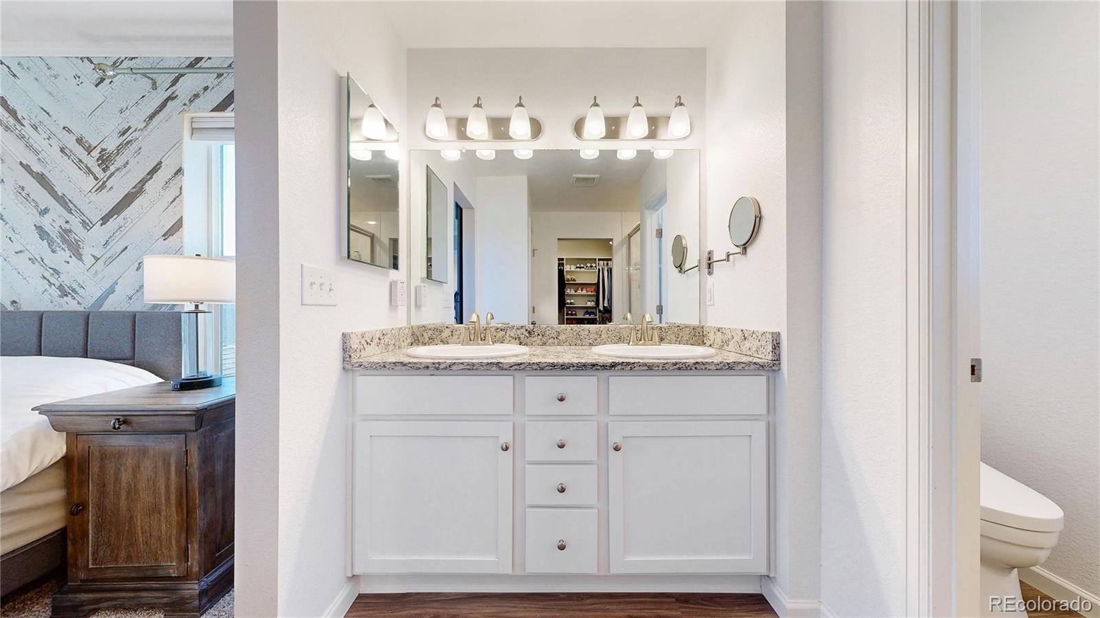 26709 East 1st Place Aurora, CO 80018 - Photo 18 of 50 a bathroom with a double vanity sink a toilet and a mirror