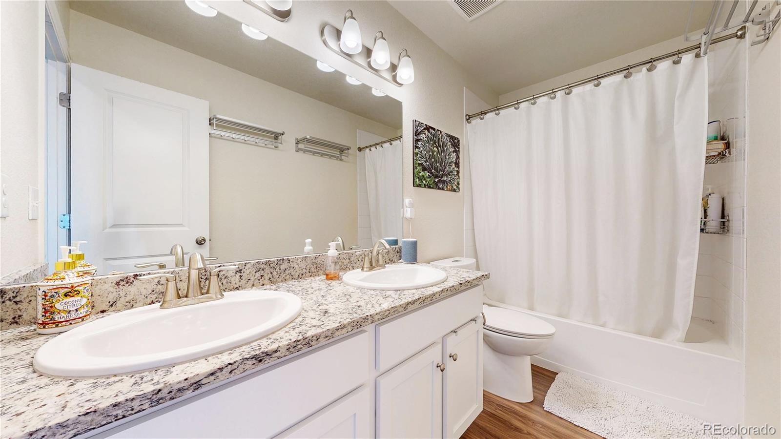 26709 East 1st Place Aurora, CO 80018 - Photo 23 of 50 a bathroom with a granite countertop sink a toilet and a mirror
