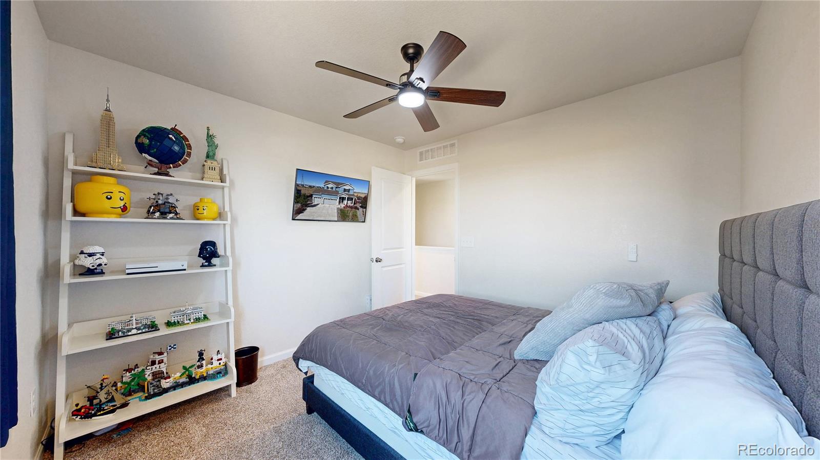 26709 East 1st Place Aurora, CO 80018 - Photo 25 of 50 a bedroom with a bed and book shelf