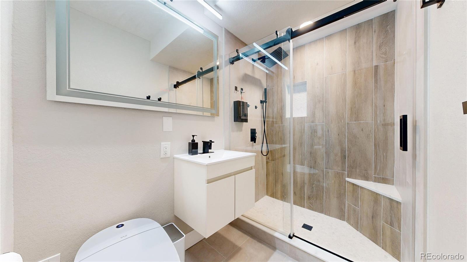 26709 East 1st Place Aurora, CO 80018 - Photo 31 of 50 a bathroom with a sink a toilet and shower